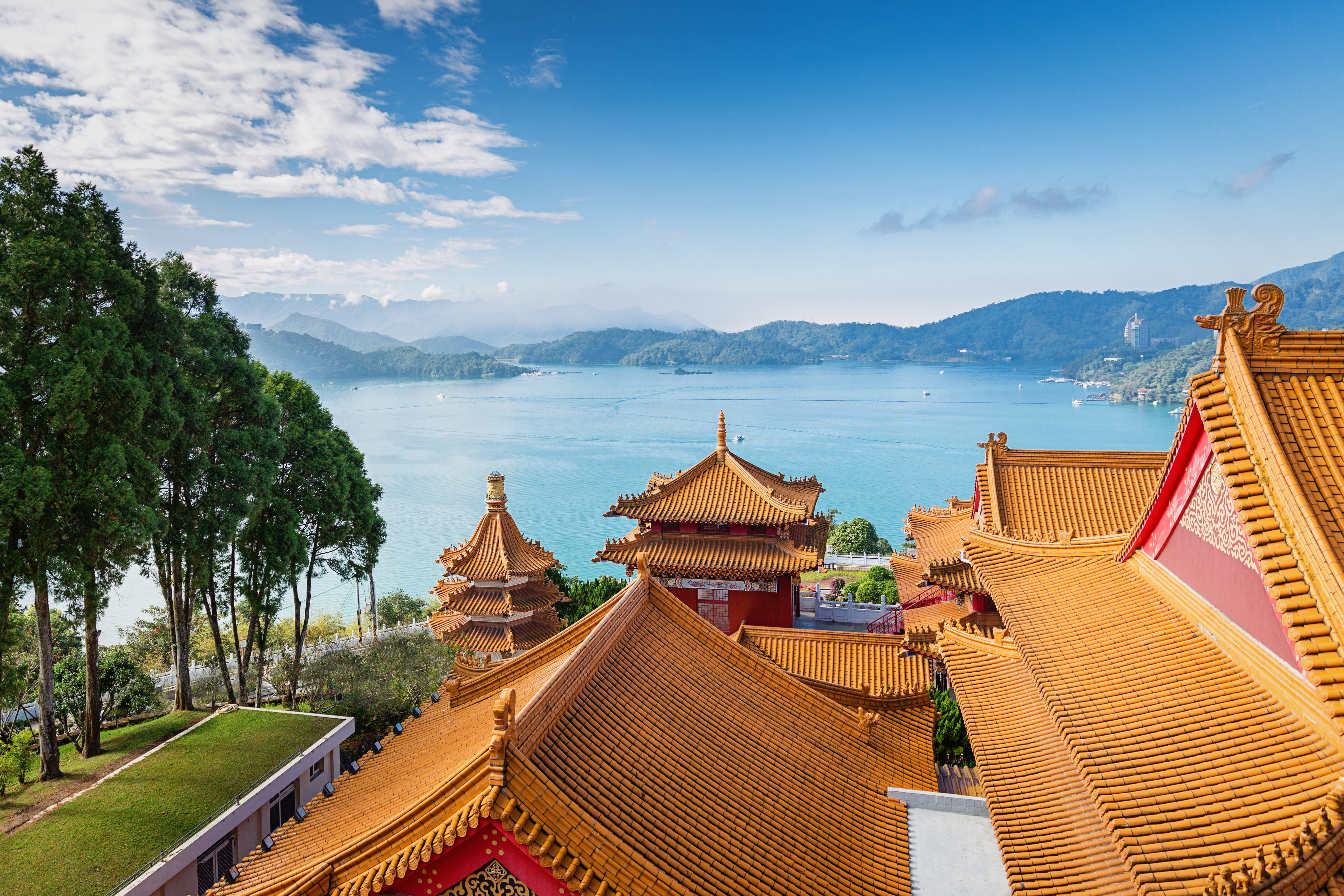 Beautiful view towards the famous Sun Moon Lake View under blue sunny sky over Wen Wu Temple Rooftops. 